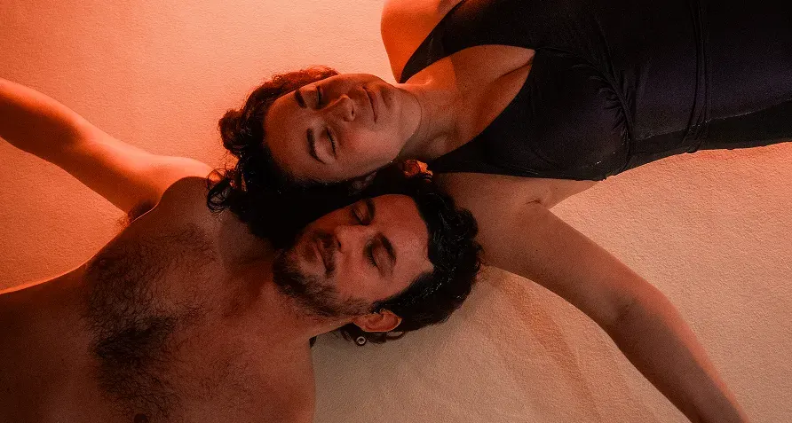 Deux visages apaisés, tête contre tête, qui flottent dans l'eau